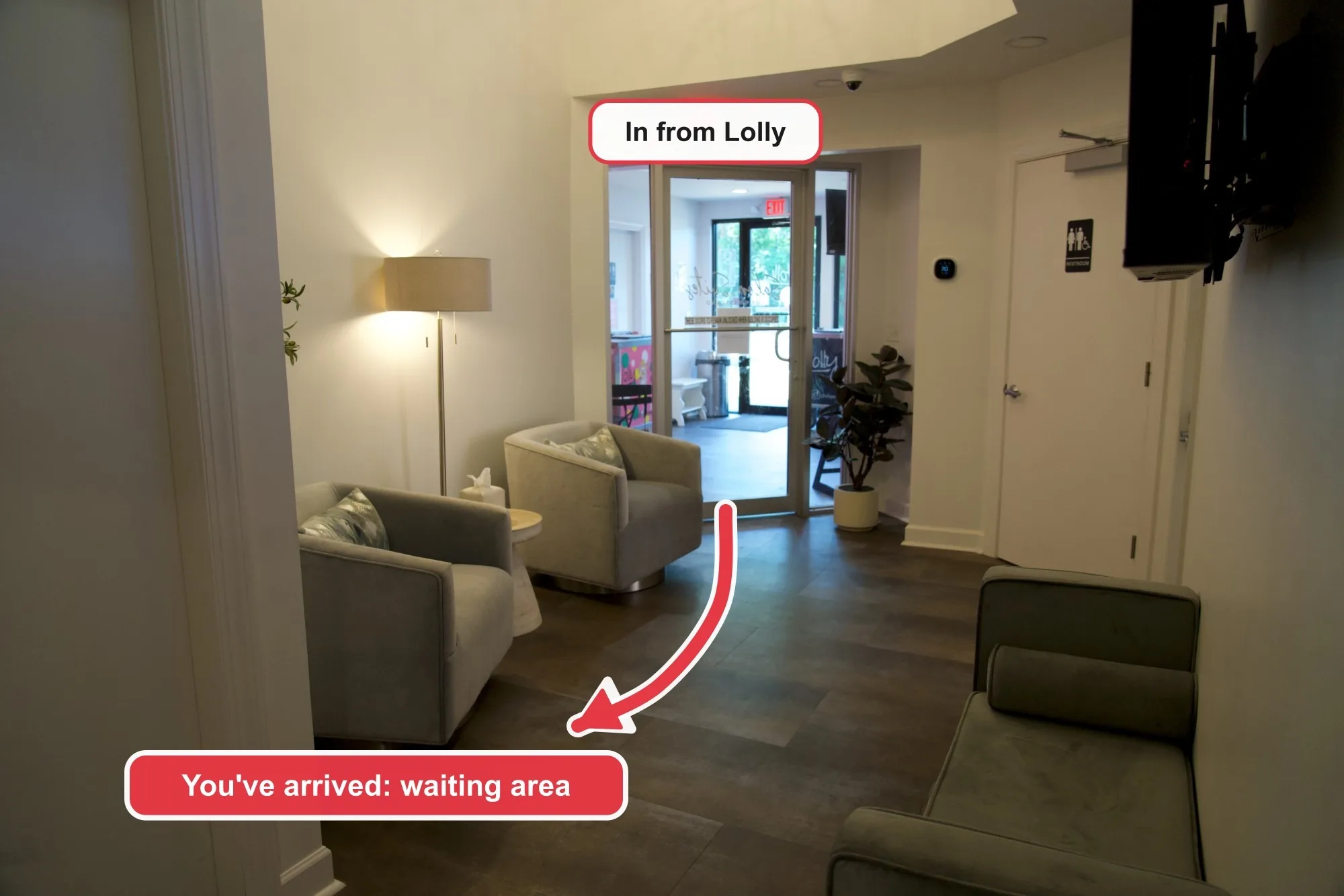 The waiting area, with gray armchairs and a floor lamp. The glass door in from Lolly is behind, and an arrow leads to the seats, labeled "You've arrived: waiting area".