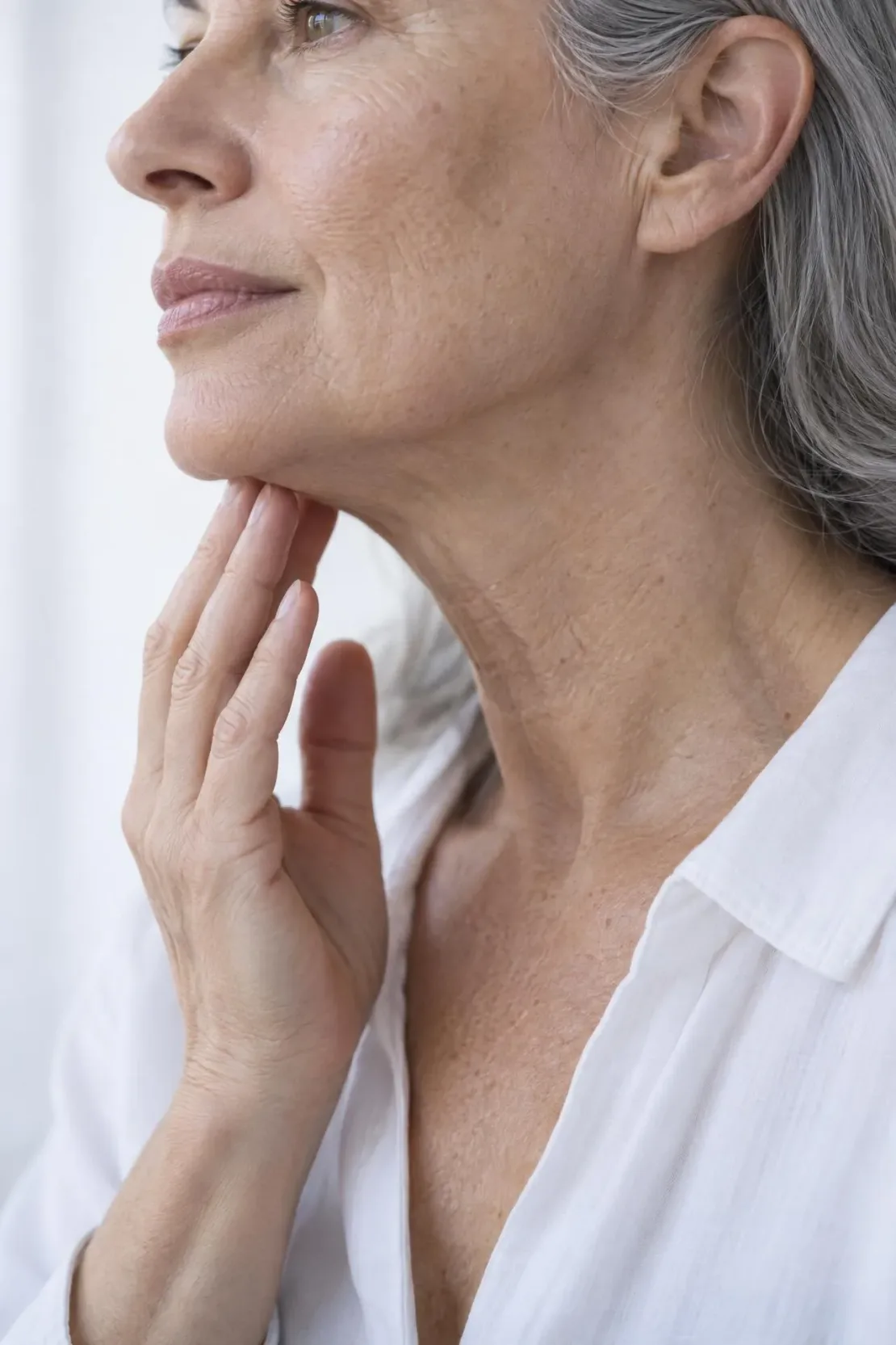 Close view of mild jowls forming along the lower jawline of an adult client during a consultation in Franklin, TN